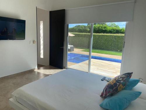 a bedroom with a large bed and a large window at Girardot Casa estilo mediterraneo con piscina privada in Girardot