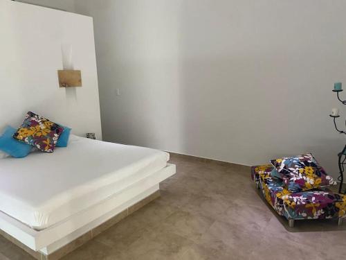 吉拉爾的住宿－Girardot Casa estilo mediterraneo con piscina privada，一间白色卧室,配有一张床和两把椅子