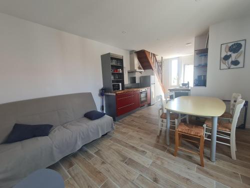 un salon avec un canapé et une table dans l'établissement Maison La tranche sur Mer proche centre ville et plages, à La Tranche-sur-Mer