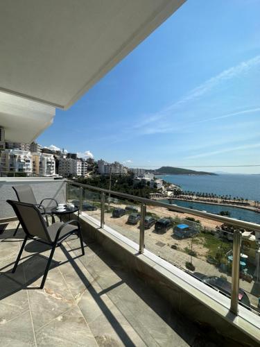 a balcony with a chair and a view of the ocean at Apartment Caroline in Sarandë
