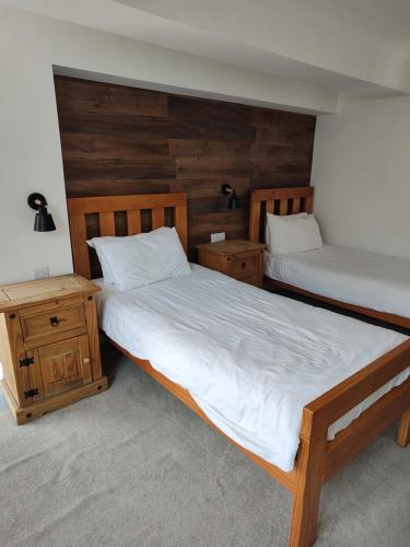 two twin beds in a room with wooden walls at The Northwick Arms Hotel in Evesham