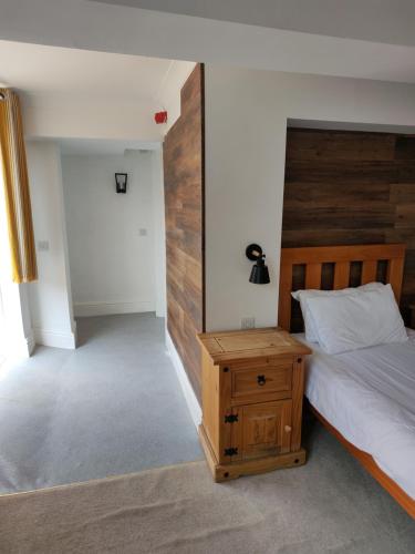 a bedroom with a bed and a wooden headboard at The Northwick Arms Hotel in Evesham