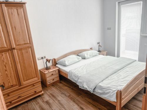 a bedroom with a bed and a wooden cabinet at Rezidencia Podhájska in Podhájska