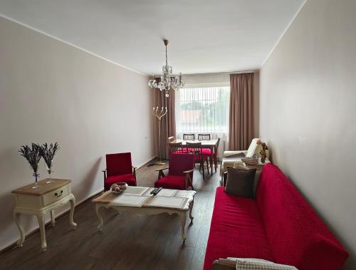 uma sala de estar com um sofá vermelho e cadeiras vermelhas em Vakaro Namai em Alytus