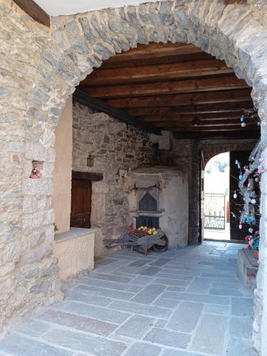 einen Torbogen in einem Steingebäude mit einem Kamin in der Unterkunft Casa Elisa apartment in Armeno