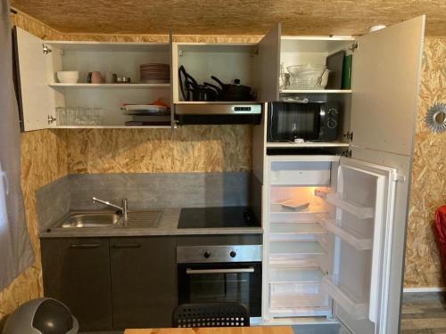 a small kitchen with white cabinets and a sink at Chalet 1 in Verrières