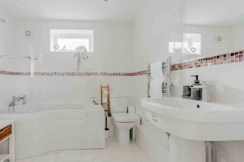 uma casa de banho branca com um lavatório e um WC em Lovely cosy annex by the sea em Bournemouth
