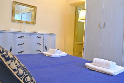 ein Schlafzimmer mit einem blauen Bett und Handtüchern darauf in der Unterkunft Gramsci Home in Volterra