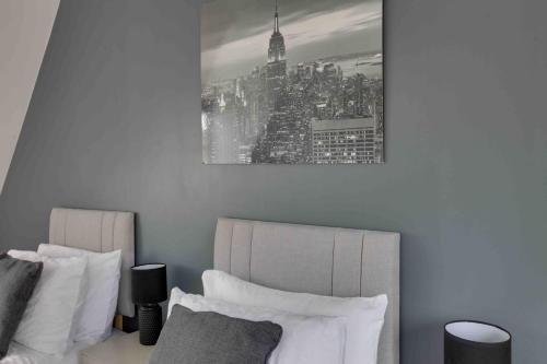 a bedroom with two beds and a picture of a city at Elizabeth II Five Bedroom Spacious Home in Bocking Churchstreet