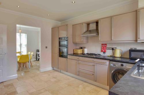 a kitchen with stainless steel appliances and a table at Elizabeth II Five Bedroom Spacious Home 