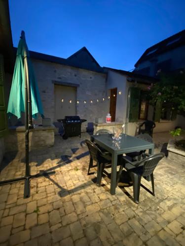une terrasse avec une table et un parasol dans l'établissement Maison cosy proche centre ville, à Compiègne