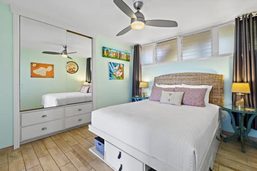 een slaapkamer met een bed en een spiegel bij Hale Ono Loa 117 in Kahana