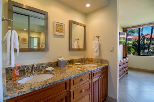 a bathroom with two sinks and a large mirror at Papakea J202 in Kahana