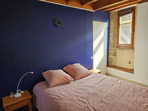 ein Schlafzimmer mit einer blauen Wand und einem Bett mit Kissen in der Unterkunft Appartement Malleval Chez Jeanne in Malleval