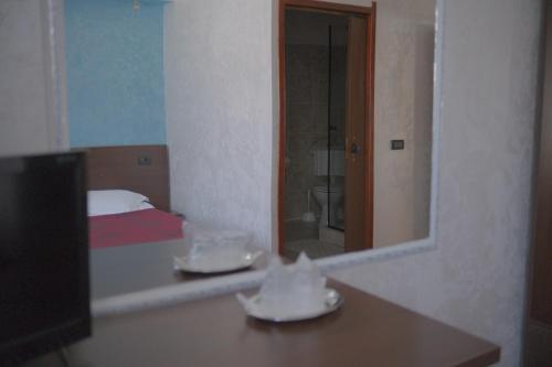 a reflection of a bedroom with a bed and a mirror at Pensiunea La Busu in Bran