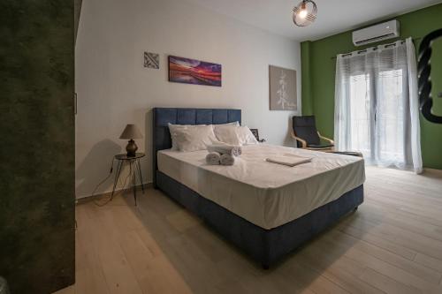 een slaapkamer met een groot bed met witte lakens en groene muren bij One Salonica Deluxe Apartment 1 in Thessaloniki