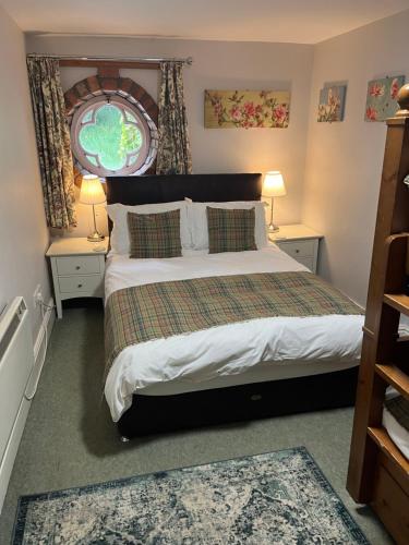 a bedroom with a large bed with two tables and two lamps at Hargate Hall Self Catering in Buxton