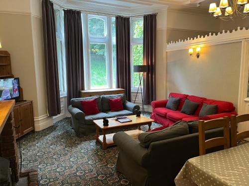 a living room with two couches and a tv at Hargate Hall Self Catering in Buxton