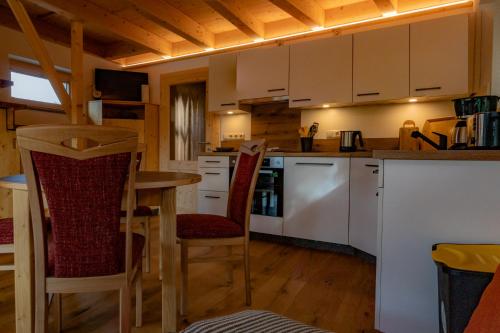 a kitchen with white cabinets and a table and chairs at Ferienhaus Siebenschläfer in Rathen