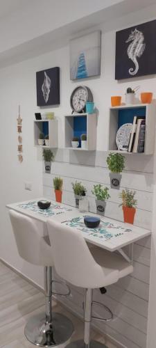 a white table in a room with plants and shelves at Biancaluna in Polignano a Mare