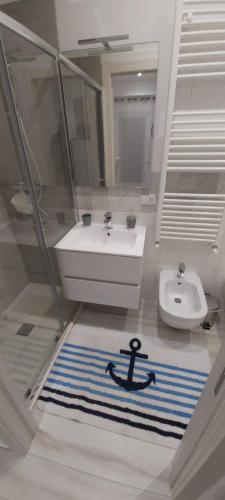 a bathroom with a sink and a black anchor on the floor at Biancaluna in Polignano a Mare