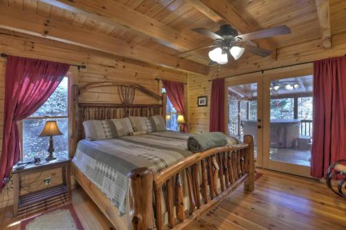 a bedroom with a bed in a log cabin at Waterfall Lodge in Ellijay