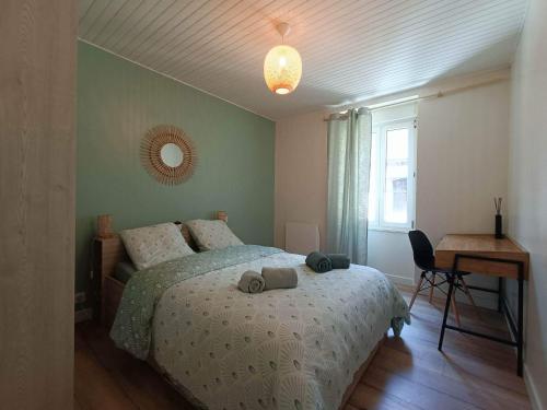 Schlafzimmer mit einem Bett, einem Tisch und einem Schreibtisch in der Unterkunft Joli cocon en hyper centre in Loudéac