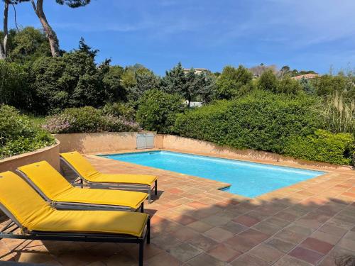 - une piscine avec 2 chaises longues à côté de la piscine dans l'établissement Villa st maxime, à Sainte-Maxime