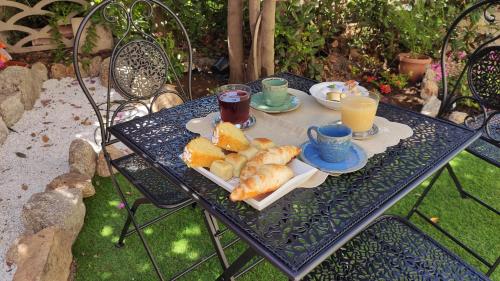een tafel met croissants en kopjes jus d'orange bij L'Ajaccio B&B in La Maddalena