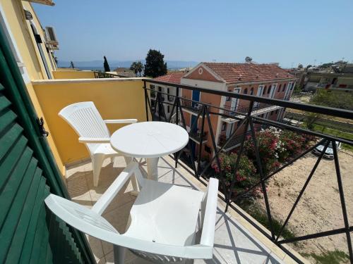 a white table and chairs on a balcony at Meraki Kavos in Kavos