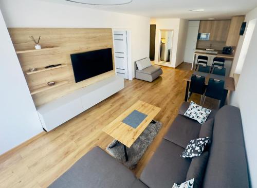 ein Wohnzimmer mit einem Sofa und einem Flachbild-TV in der Unterkunft Urban PORT apartment in Liptovský Mikuláš