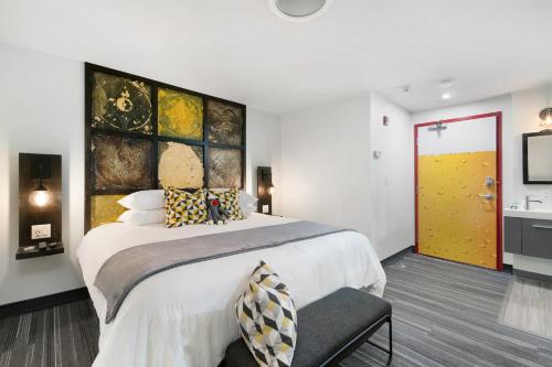 a bedroom with a large bed and a yellow door at Inn 15 Brewery Loft Suites in Kingsville