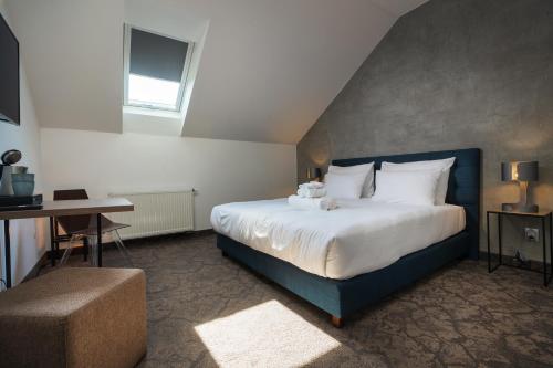 a bedroom with a large bed and a desk at Riverside Hotel Plzeň in Pilsen