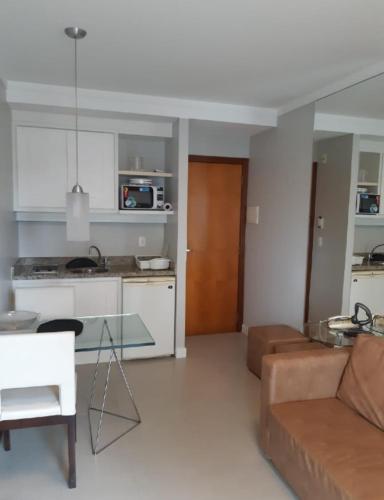 a kitchen and a living room with a couch and a table at Flat 704 Triângulo Apart in Vitória