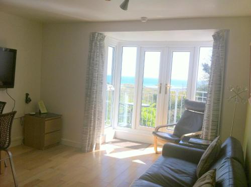 a living room with a couch and a large window at Culver House Hotel in Port-Eynon