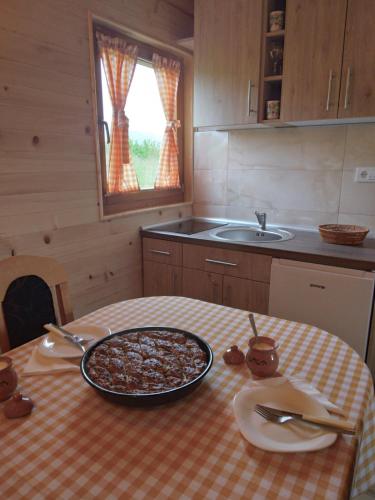 a kitchen with a table with a pizza on it at Brvnara Srna Zlatar in Nova Varoš