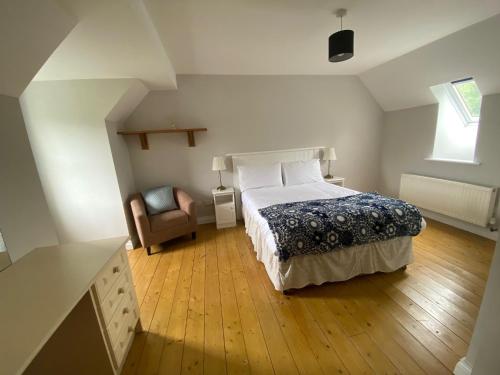 a bedroom with a bed and a chair at No 3 Aughrim Holiday Village in Aughrim