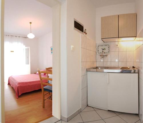 a kitchen with a sink and a room with a bed at Apartments Lanterna in Sućuraj