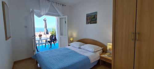sypialnia z łóżkiem i widokiem na ocean w obiekcie Apartments Lanterna w mieście Sućuraj