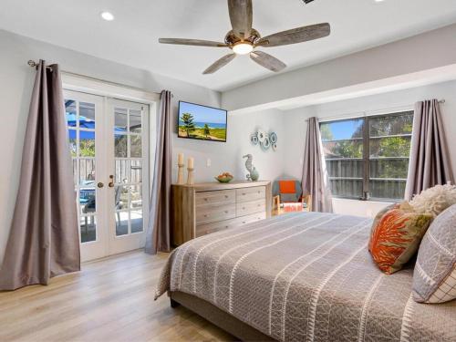 una camera da letto con un letto e un ventilatore a soffitto di Lake Park Cottage a Naples