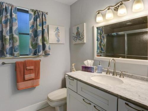 un bagno con lavandino, WC e finestra di Lake Park Cottage a Naples