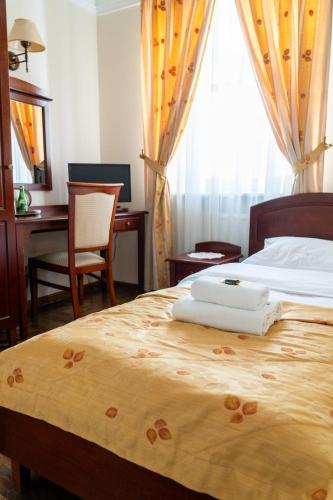 a bedroom with a bed with two towels on it at Aparthotel Karmel in Kraków