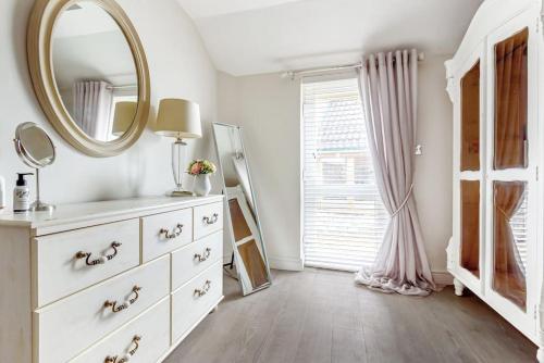 a dressing room with a mirror and a dresser at The Cowshed in Farmborough