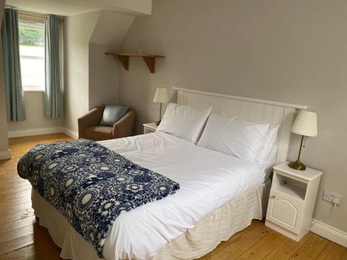 sypialnia z dużym białym łóżkiem i krzesłem w obiekcie No 3 Aughrim Holiday Village w mieście Aughrim