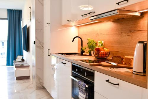 a kitchen with a counter with vegetables on it at Solaris Darłówko Premium Emilia Strupiechowska in Darłowo