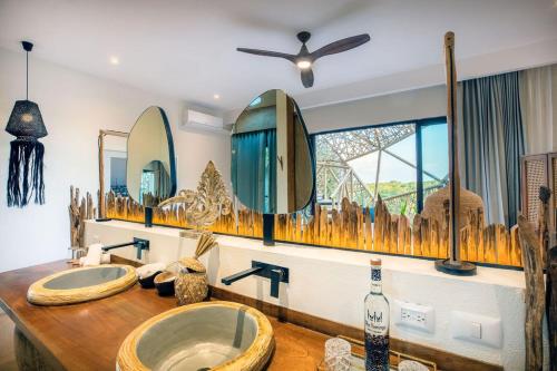 a bathroom with a sink with two mirrors and a window at Hotel Villas Flamingos in Holbox Island