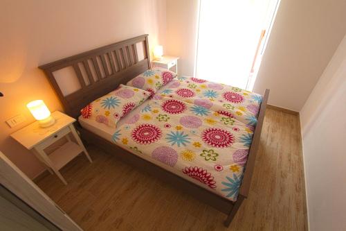 a bed with a colorful comforter and pillows on it at Apartments Maligoj in Tolmin