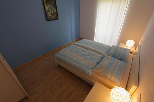 a small bedroom with a bed with blue walls at Apartments Maligoj in Tolmin