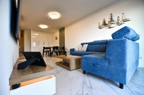 a living room with a blue couch and a table at Solaris Darłówko Premium Emilia Strupiechowska in Darłowo