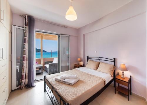 a bedroom with a bed with a view of the ocean at Summer Breeze apartment in Póndi